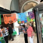 People in theater lobby with fiesta decorations.